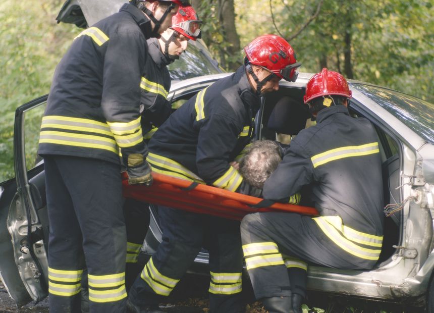 Emergency crews removing an injured driver from a wrecked car